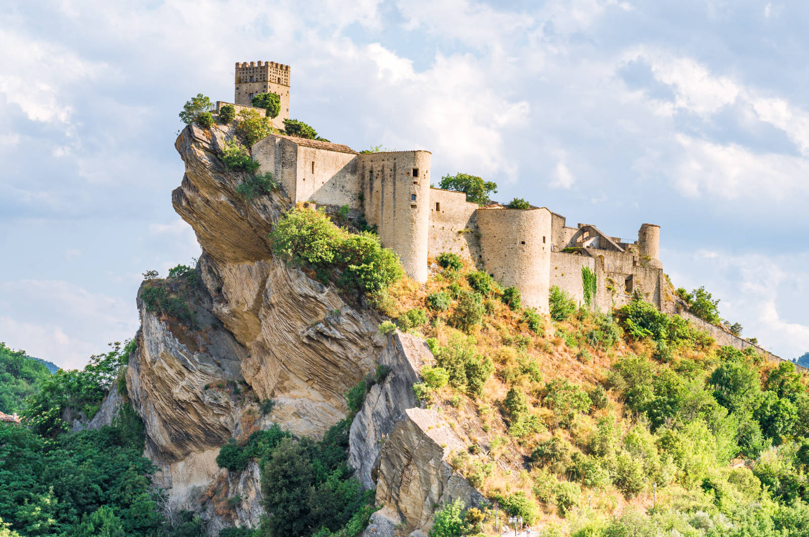 Castello di Roccascalegna in cima a uno sperone di roccia, con il torrione merlato e le torri cilindriche lungo le mura